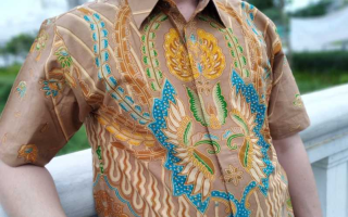 Model mengenakan dress batik modern dengan latar belakang perkotaan